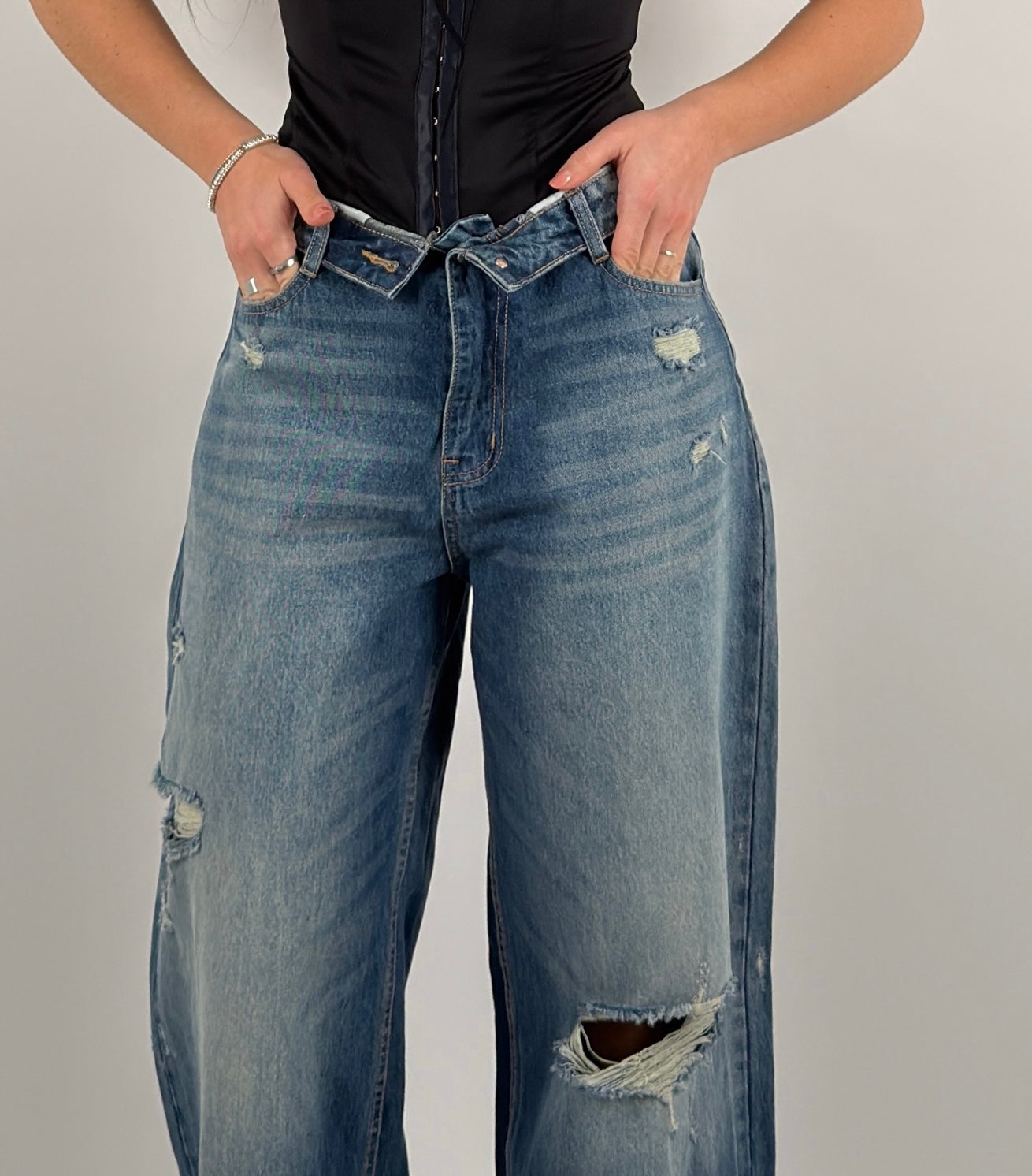 Jeans con strappi e risvolto in vita